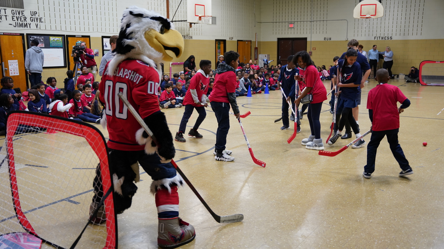 students playing floor hockey with Washington Capitals mascot