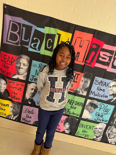 student in front of Black History Month banner